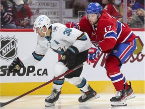 Montreal Canadiens' Josh Anderson leans on San Jose Sharks' Mario Ferraro during third period in Montreal on Oct. 19, 2021.