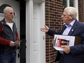 Kirkland incumbent mayor Michel Gibson (right) speaks with resident Gary Bowman while doing door-to-door campaigning .