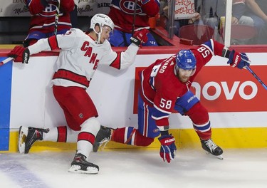 Carolina Hurricanes' Jesperi Kotkaniemi falls against the boards after check on Montreal Canadiens' David Savard during first period at the Bell Centre Thursday, Oct. 21, 2021.