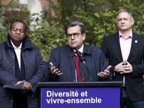 Montreal mayoralty candidate Denis Coderre speaks as Gabriel Retta, candidate for city councillor in the
Cote-Des-Neiges–Notre-Dame-De-Grace Loyola borough, left, and Daniel Vaudrin, candidate for city councillor for the Ville-Marie Sainte-Marie borough, look on Sunday, Oct. 24, 2021.