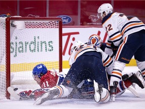 Montreal Canadiens' Brendan Gallagher crashes into the net after diving past Edmonton Oilers goaltender Mikko Koskinen to score in Montreal on March 30, 2021.