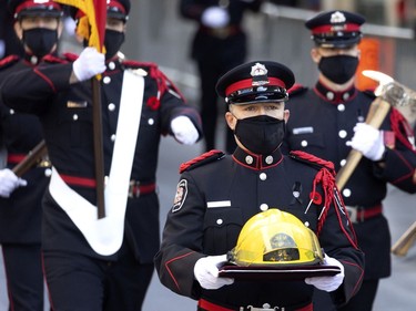 The Montreal Fire Department honour guard carries the helmet of fallen firefighter Pierre Lacroix during his funeral service in Montreal on Friday, Oct. 29, 2021.