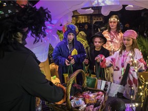 On a rainy Halloween night in Montreal Sunday, from left: Eliott Seivewright, Alec Seivewright, Emma Wyatt and Eva Langlois get some candy at a Montreal West home.