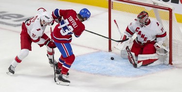Montreal Canadiens Tyler Toffoli shoots the puck past Carolina Hurricanes goalie Frederik Andersen while being pressured by defenceman Brett Pesce for a power-play goal during second period at the Bell Centre Thursday, Oct.21, 2021.
