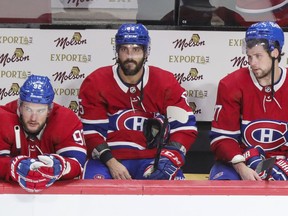 Montreal Canadiens' Jonathan Drouin, Mathieu Perreault and Josh Anderson stay on the bench following the final siren in their loss to the Carolina Hurricanes in Montreal on Oct. 21, 2021.