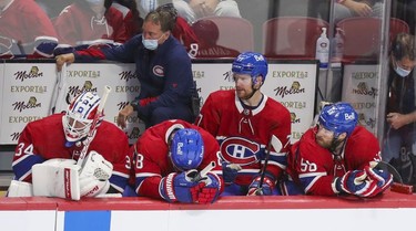 Montreal Canadiens Jake Allen, left, Ben Chiarot, Brett Kulak and David Savard sit through the last minute of their loss to the Carolina Hurricanes at the Bell Centre Thursday, Oct. 21, 2021.  Equipment manager Pierre Gervais watches at rear.