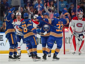 Sabres' Zemgus Girgensons celebrates with teammates after scoring a goal against Canadiens goalie Samuel Montembeault Thursday night at the KeyBank Arena in Buffalo.
