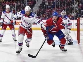 K'Andre Miller of the New York Rangers and Christian Dvorak  of the Montreal Canadiens skate after the puck during the second period at the Bell Centre on Oct. 16, 2021.
