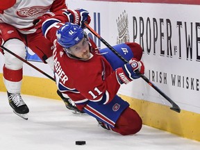 Brendan Gallagher of the Montreal Canadiens falls as he skates with the puck against Nick Leddy of the Detroit Red Wings during the second period at the Bell Centre on Oct. 23, 2021.