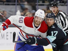 Montreal Canadiens' Joel Armia and Jaden Schwartz of the Seattle Kraken battle for a loose puck during the first period in Seattle Oct. 26, 2021.