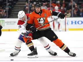 Ryan Getzlaf of the Anaheim Ducks battles Canadiens' Nick Suzuki  for a loose puck at the Honda Center on Sunday, Oct. 31, 2021, in Anaheim, Calif.
