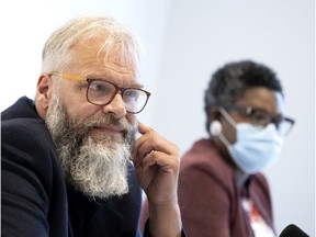 Alain Croteau of CSN listens to a reporter's questions as Guerda Amazan of Maison d'Haiti looks on, during a news conference about systemic discrimination in the health care system, in Montreal, on Tuesday, Oct. 5, 2021.