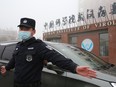 A security guard directs traffic as vehicles carrying WHO members arrive at Wuhan Institute of Virology in Wuhan City, Hubei Province, China on February 3, 2021.