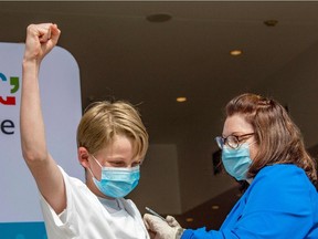 Charles Muro, 13, celebrates being inoculated by nurse Karen Pagliaro in Hartford, Conn. Canadian authorities say approval for vaccinating 5 to 11-year-olds in this country is unlikely to come before "mid-to end-November."