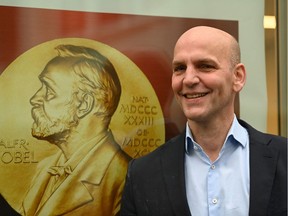 Benjamin List, co-winner of the 2021 Nobel Prize in Chemistry, poses next to a poster of the Nobel Prize at the Max Planck Institute for Coal Research in Germany on Oct. 6, 2021.