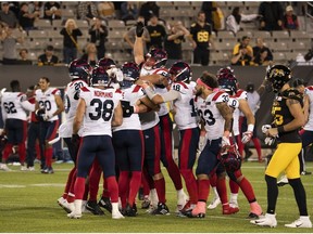 Alouettes players swarm Montreal kicker David Côté (15) after his game-winning filed goal during overtime CFL football game action against the Tiger Cats in Hamilton on Saturday, Oct. 2, 2021.