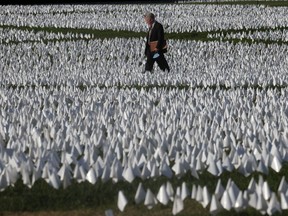 People visit Brennan Firstenberg's In America: Remember, a memorial for Americans who died because of the coronavirus disease (COVID-19) as the national death toll hits 700,000, next to the Washington Monument in Washington on Friday, Oct. 1, 2021.