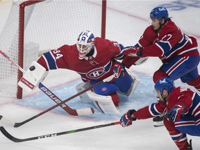 Canadiens goaltender Jake Allen makes a save against the New York Rangers as Canadiens' Alexander Romanov (27) and Cedric Paquette (13) look for the rebound at the Bell Centre in Montreal on Saturday, Oct. 16, 2021.