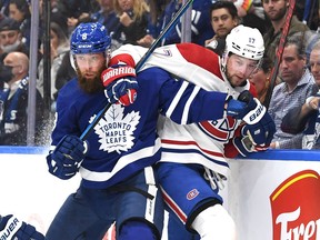 Canadiens forward Josh Anderson  battles along the boards with Leafs defenceman Jake Muzzin during first period at Scotiabank Arena Wednesday night.