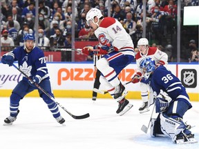 Canadiens forward Nick Suzuki tries to screen Leafs goalie Jack Campbell as T.J. Brodie, left, looks on Wednesday night at Scotiabank Arena.