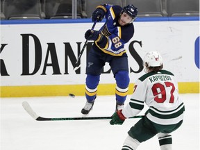 Blues' Mike Hoffman flips the puck past the Wild's Kirill Kaprizov last season. Hoffman signed a three-year, US$13.5-million contract with the Canadiens this off-season.