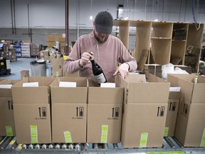 An SAQ worker loads online orders at east-end warehouse in 2020.