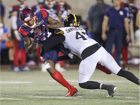 Montreal Alouettes' Eugene Lewis is tackled by Hamilton Tiger Cats Jovan Santos-Knox in Montreal on Aug. 27, 2021.