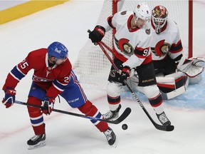 Montreal Canadiens' Ryan Poehling and Ottawa Senators' Josh Norris try to gain control of the puck in front of goaltender Anton Forsberg during pre-season game in Montreal on Oct. 7, 2021.