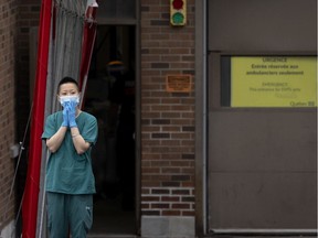 A health care worker takes a short break outside the triage area of the St. Mary's Hospital ER, in Montreal, on Thursday, October 14, 2021.