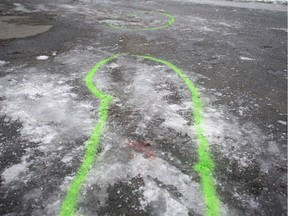 Police markings outline an area where blood stains mark the spot of a stabbing in Marc-Aurèle-Fortin Park north of Montreal on Thursday, Jan. 2, 2020.
