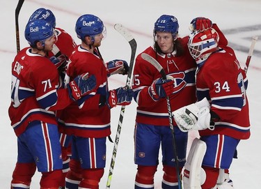 Montreal Canadiens goaltender Jake Allen is congratulated by teammates Sami Niku (15), Brett Kulak (77) and Jake Evans (71) following third-period action in Montreal on Tuesday, Nov. 2, 2021.