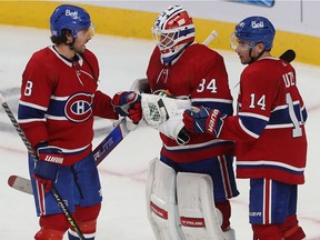 Montreal Canadiens goaltender Jake Allen his congratulated by teammates Ben Chiarot, left, and Nick Suzuki after shutting out the Detroit Red Wings in Montreal on Nov. 2, 2021.