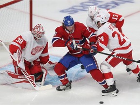 Montreal Canadiens' Christian Dvorak battles for the puck in front of Detroit Red Wings goaltender Alex Nedeljkovic as Pius Suter and Filip Hronek move in on the play during first period in Montreal on Nov. 2, 2021.