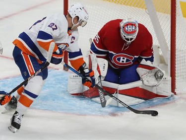 Montreal Canadiens goaltender Sam Montembeault keeps an eye on the puck as New York Islanders' Anders Lee (27) comes in for the shot on goal during third-period action in Montreal on Thursday, Nov. 4, 2021.