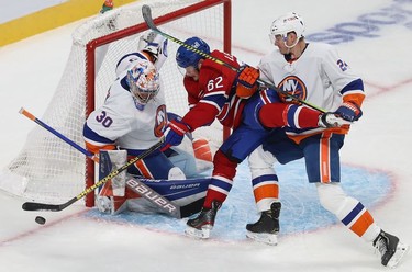 Montreal Canadiens' Artturi Lehkonen (62) tries in vain to make a move on New York Islanders goaltender Ilya Sorokin while being grabbed by Scott Mayfield (24) during third-period action in Montreal on Thursday, Nov. 4, 2021.
