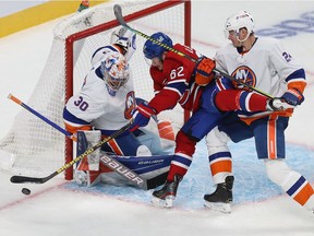 Montreal Canadiens' Artturi Lehkonen tries in vain to make a move on New York Islanders goaltender Ilya Sorokin while being grabbed by Scott Mayfield during third period in Montreal on Nov. 4, 2021.