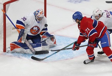Montreal Canadiens' Jake Evans (71) looks at puck going off shoulder of New York Islanders goaltender Ilya Sorokin during first-period action in Montreal on Thursday, Nov. 4, 2021.