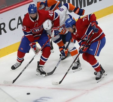 Montreal Canadiens' Joel Armia (40) slows down New York Islanders Oliver Wahlstrom (26), which gives time to teammates Jake Evans (71) to get to the puck, during first-period action in Montreal on Thursday, Nov. 4, 2021.