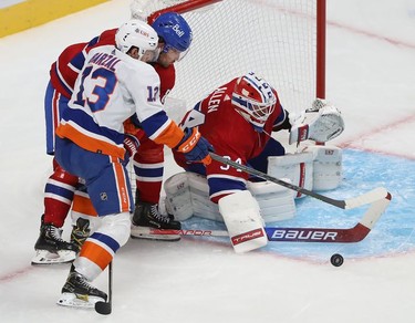New York Islanders' Mathew Barzal (13) is pushed away from puck by Montreal Canadiens' Ben Chiarot (8) in front of goaltender Jake Allen during second-period action in Montreal on Thursday, Nov. 4, 2021.