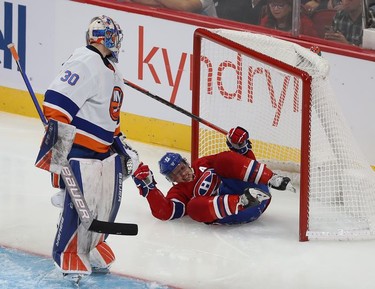 Montreal Canadiens' Brendan Gallagher (11) falls into the net of New York Islanders goaltender Ilya Sorokin during second-period action in Montreal on Thursday, Nov. 4, 2021.