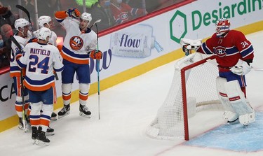 Montreal Canadiens goaltender Jake Allen looks back at New York Islanders' celebration of  hat-trick by Brock Nelson (29) during second-period action in Montreal on Thursday, Nov. 4, 2021.