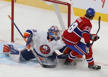 The puck is stopped by the mask of New York Islanders goaltender Ilya Sorokin on a breakaway by Montreal Canadiens' Christian Dvorak (28) during second-period action in Montreal on Thursday, Nov. 4, 2021.