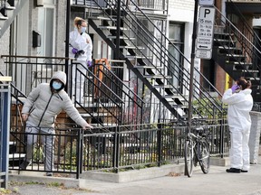 A man who lives upstairs passes crime scene investigators working at a triplex where two bodies were found dead on St-Urbain St. at the corner of Fairmont Nov. 5, 2021.