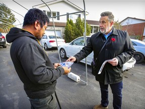 Incumbent Pierrefonds-Roxboro borough mayor Jim Beis talks with Jonathan Pagador while going door-to-door on Maplewood St. in the borough west of  Montreal on Nov. 4, 2021.