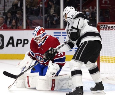 Montreal Canadiens goaltender Jake Allen (34) tries to reel in the puck as Los Angeles Kings right wing Dustin Brown (23) looks for a rebound at the Bell Centre on Tuesday, Nov. 9, 2021.