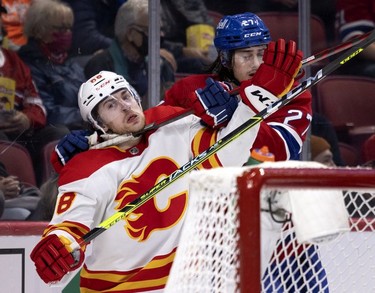 Calgary Flames left wing Andrew Mangiapane (88) grimaces as Montreal Canadiens defenseman Alexander Romanov (27) ties him up during 2nd-period NHL action in Montreal on Thursday, Nov. 11, 2021.