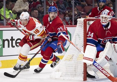 Montreal Canadiens centre Ryan Poehling shadows Calgary Flames centre Tyler Pitlick (18) behind Montreal Canadiens goaltender Jake Allen (34) net during 2nd-period NHL action in Montreal on Thursday, Nov. 11, 2021.