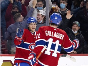 Canadiens' Brendan Gallagher congratulates Jake Evans after he scored an empty-net goal to wrap up Montreal's 4-2 victory over the Flames Thursday night at the Bell Centre.