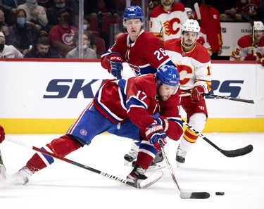 Calgary Flames left wing Johnny Gaudreau (13), Montreal Canadiens centre Christian Dvorak (28) watch as Montreal Canadiens right wing Josh Anderson (17) carries the up the ice during 3rd-period NHL action in Montreal, on Thursday, Nov. 11, 2021.