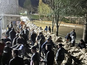 Volunteers stack sandbags at Barrowtown Pump Station in an all-night effort that saved the critical pumping station from being inundated, in Abbotsford, B.C.